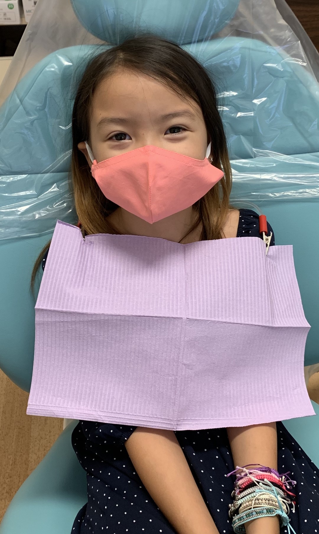 Child wearing a pink face mask, smiling